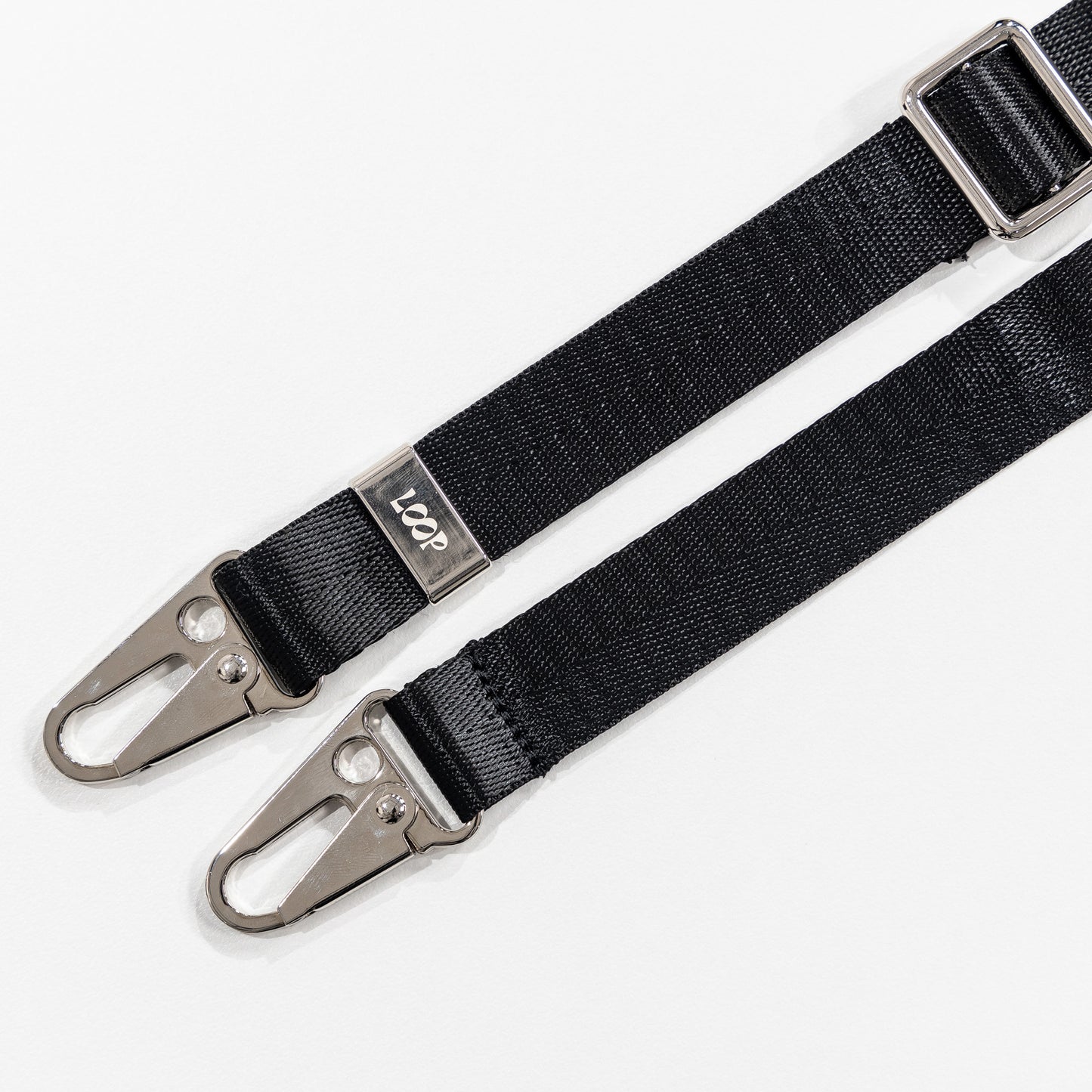 Black loop crossbody strap laying flat 
