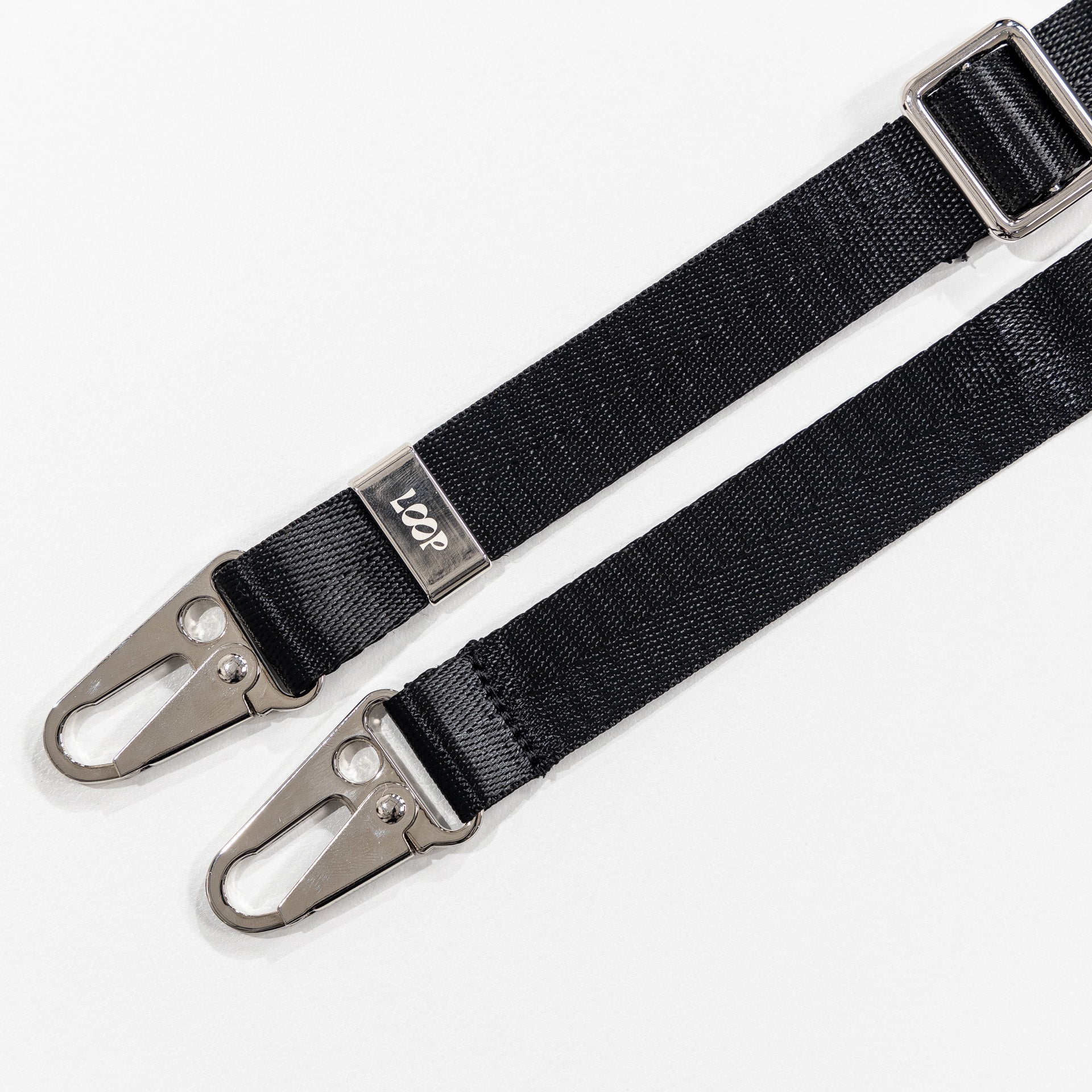 Black loop crossbody strap laying flat 