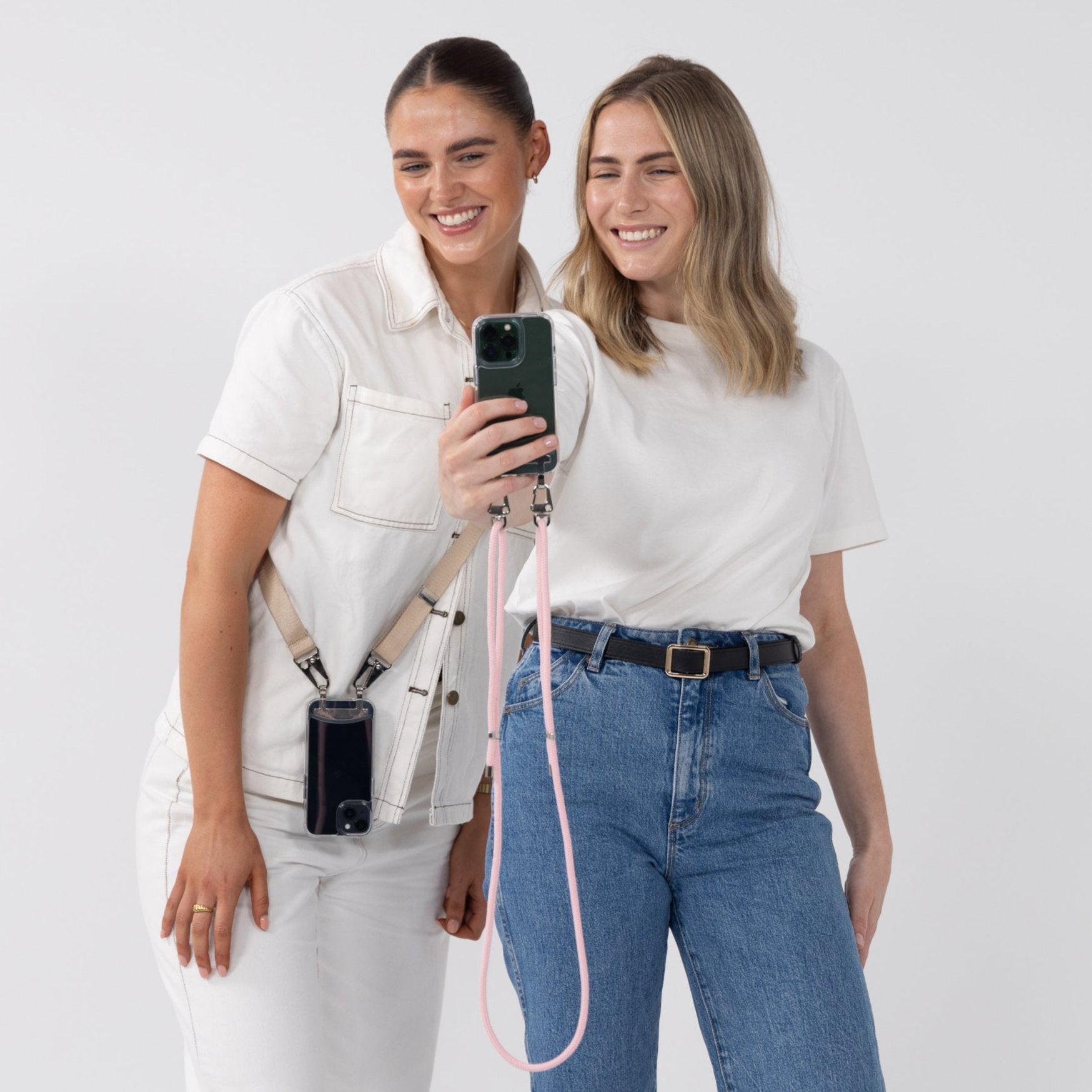 Two clear crossbody phone cases with latte phone strap and blush cord attached.