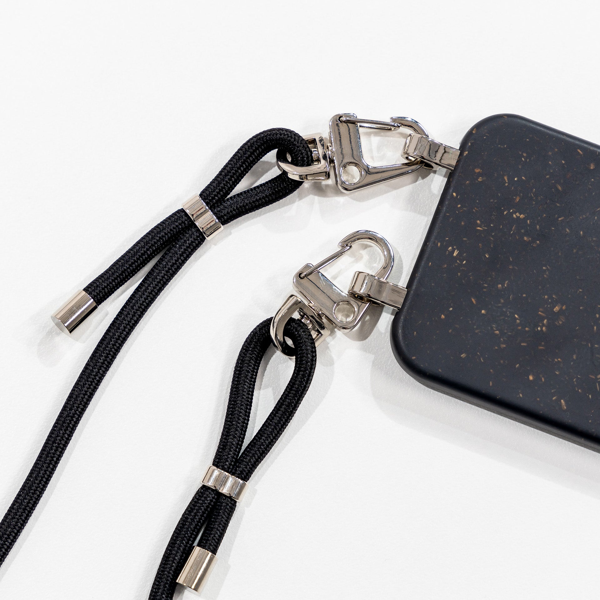 Ink crossbody phone case with black cord face down lay flat 