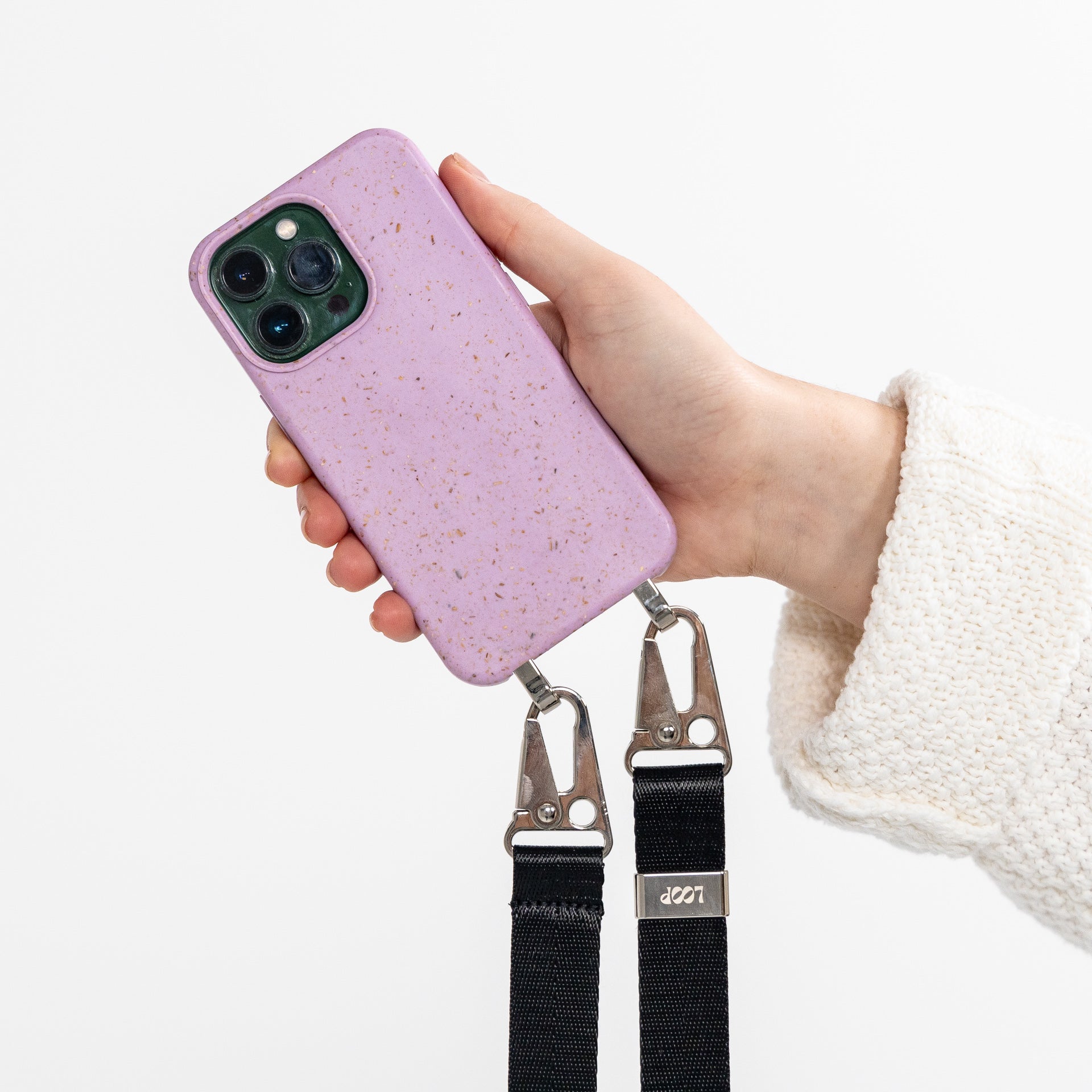 Lavender crossbody phone case with black strap attached being held in hand 