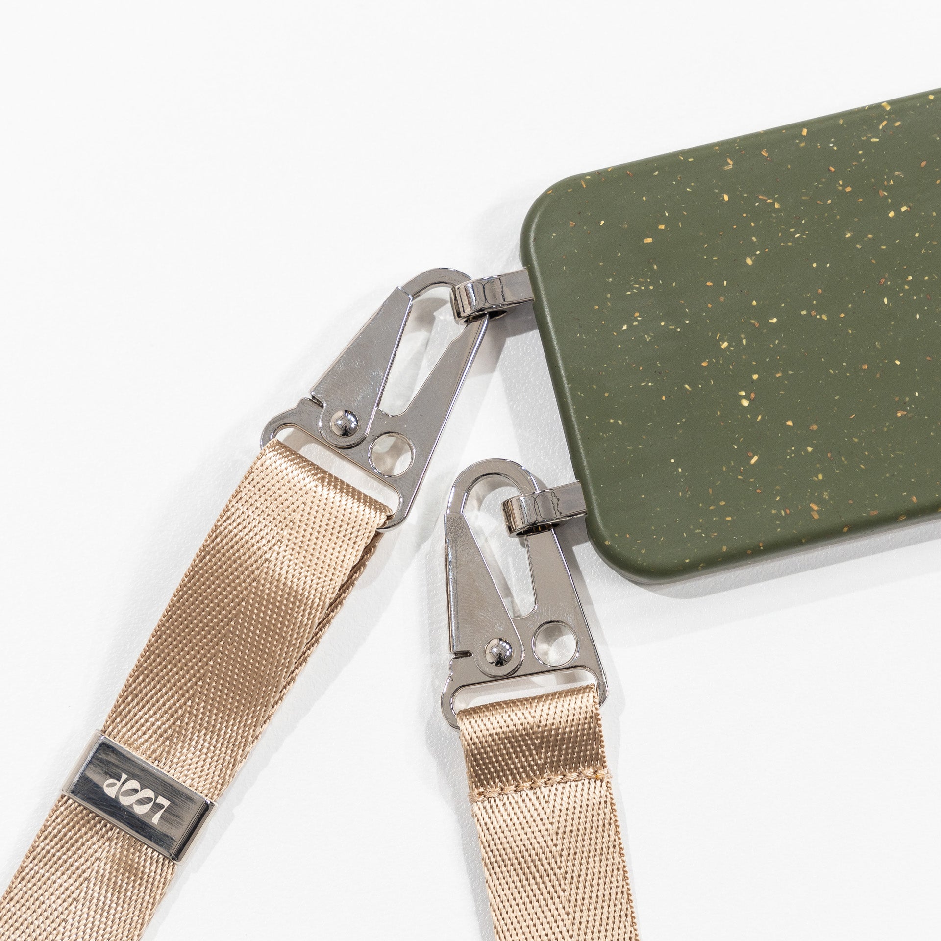 Pesto Loop crossbody phone case with latte strap attached close up flat lay