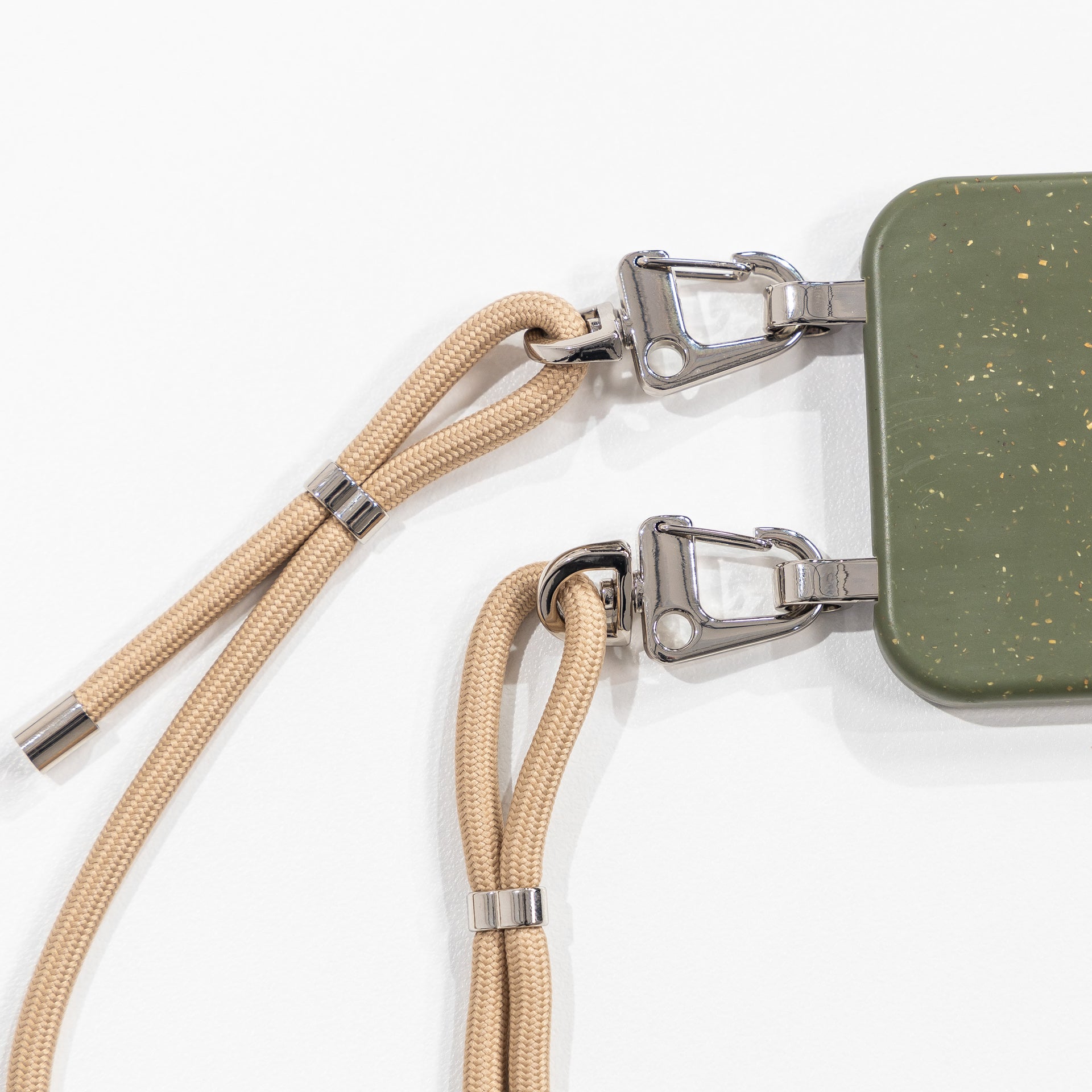 Loop crossbody phone case pesto with tapioca cord laying face down 