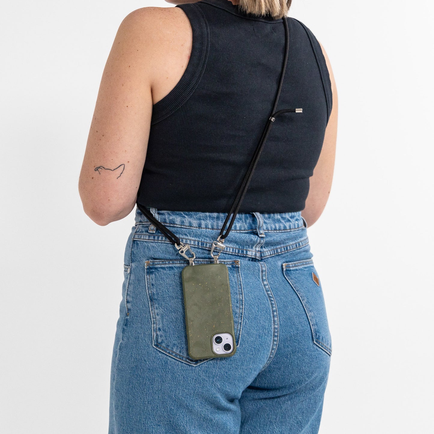 Pesto crossbody phone case with black cord hanging over shoulder from behind