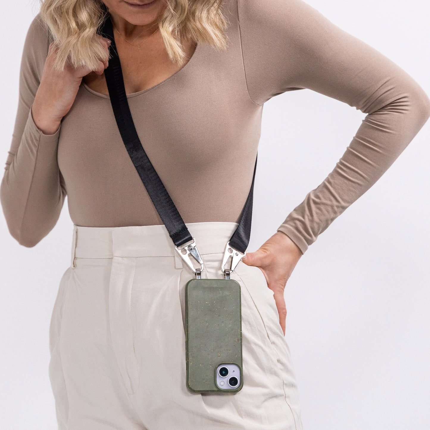 Pesto crossbody phone case with black strap worn over shoulder 