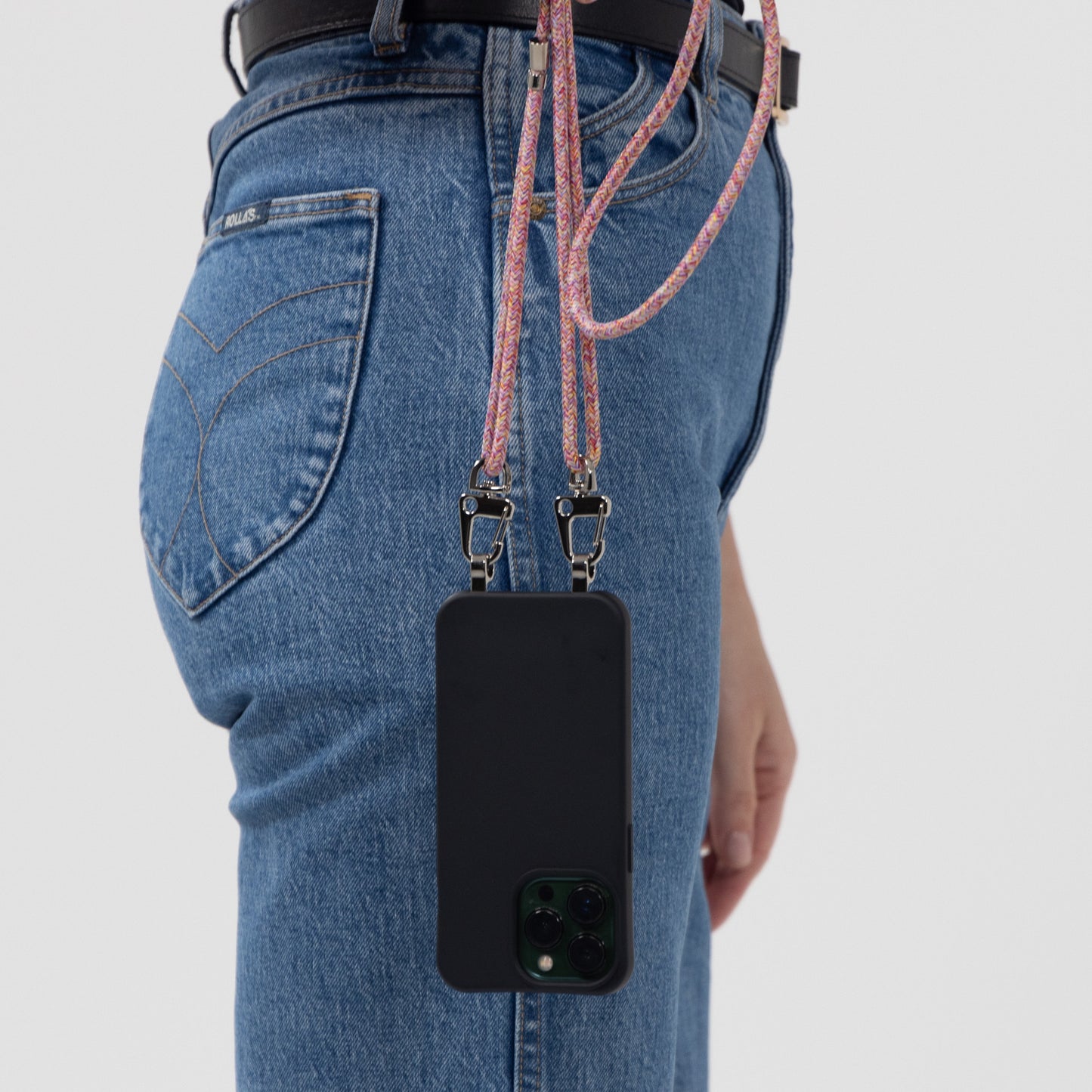 Loop crossbody cord sangria with black case hanging side profile next to models hip