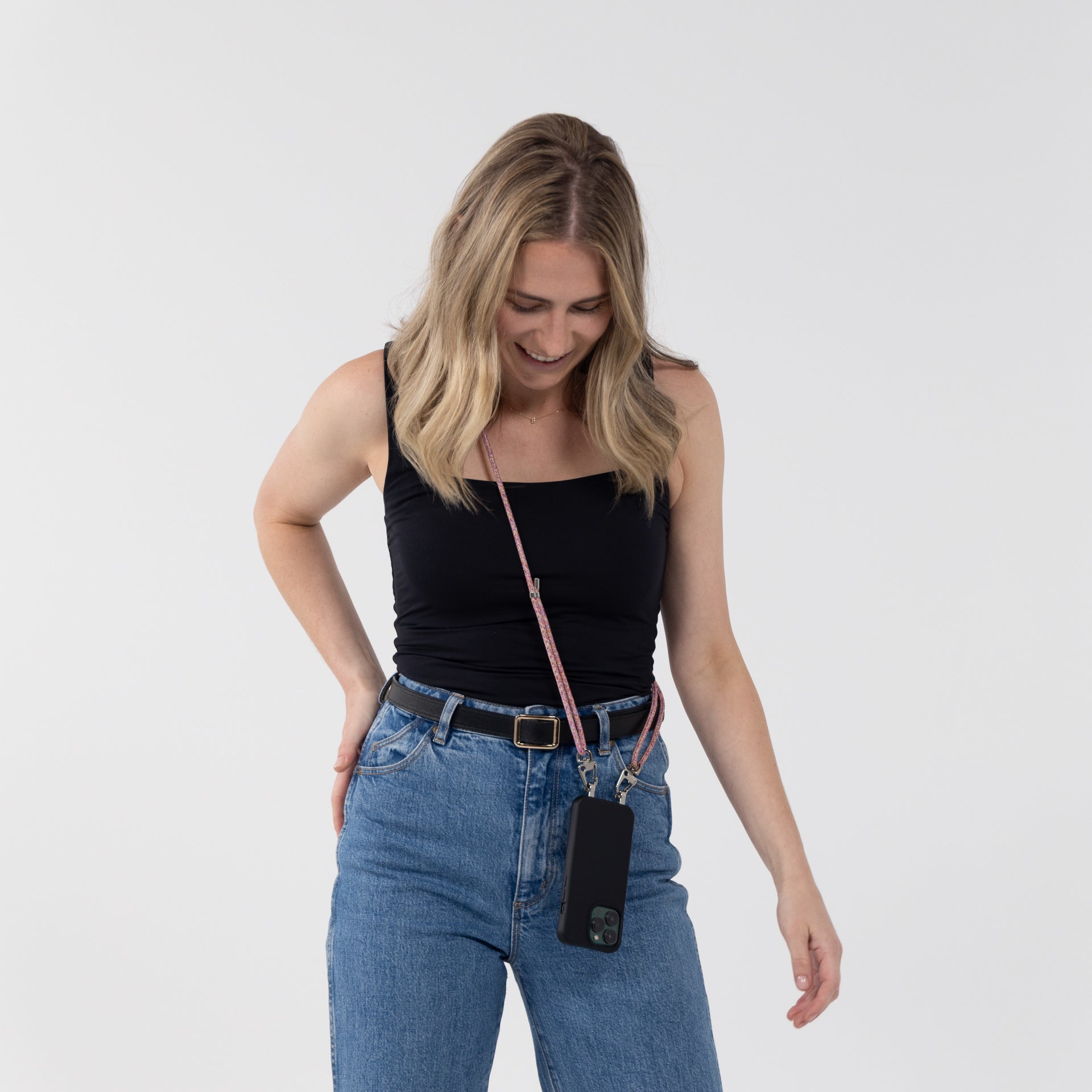 Sangria crossbody cord with black crossbody phone case worn across shoulder