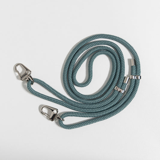 Crossbody cord seafoam coiled up flat lay with no phone case