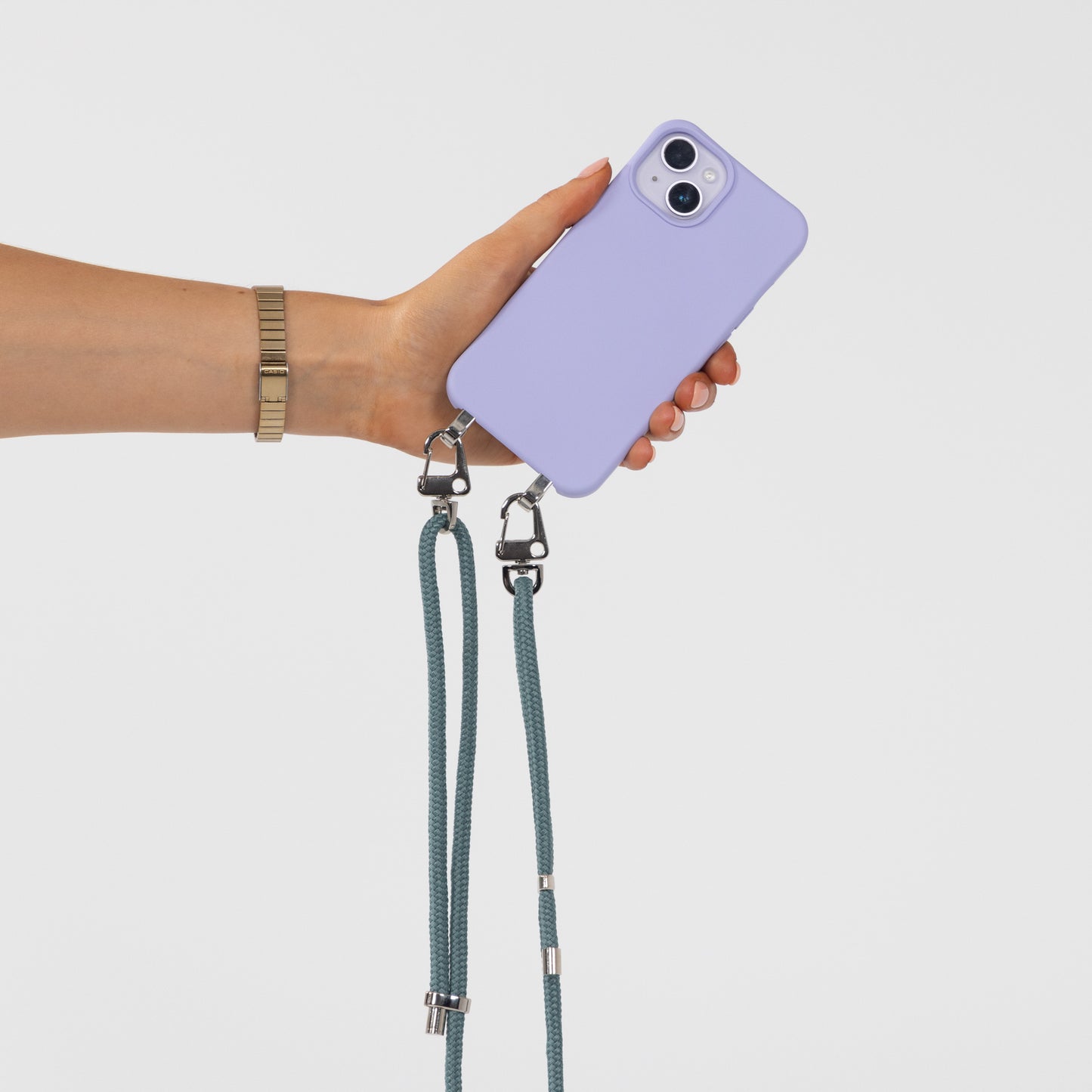 Lilac Loop crossbody phone case with seafoam cord attached being held in hand with rear of phone view