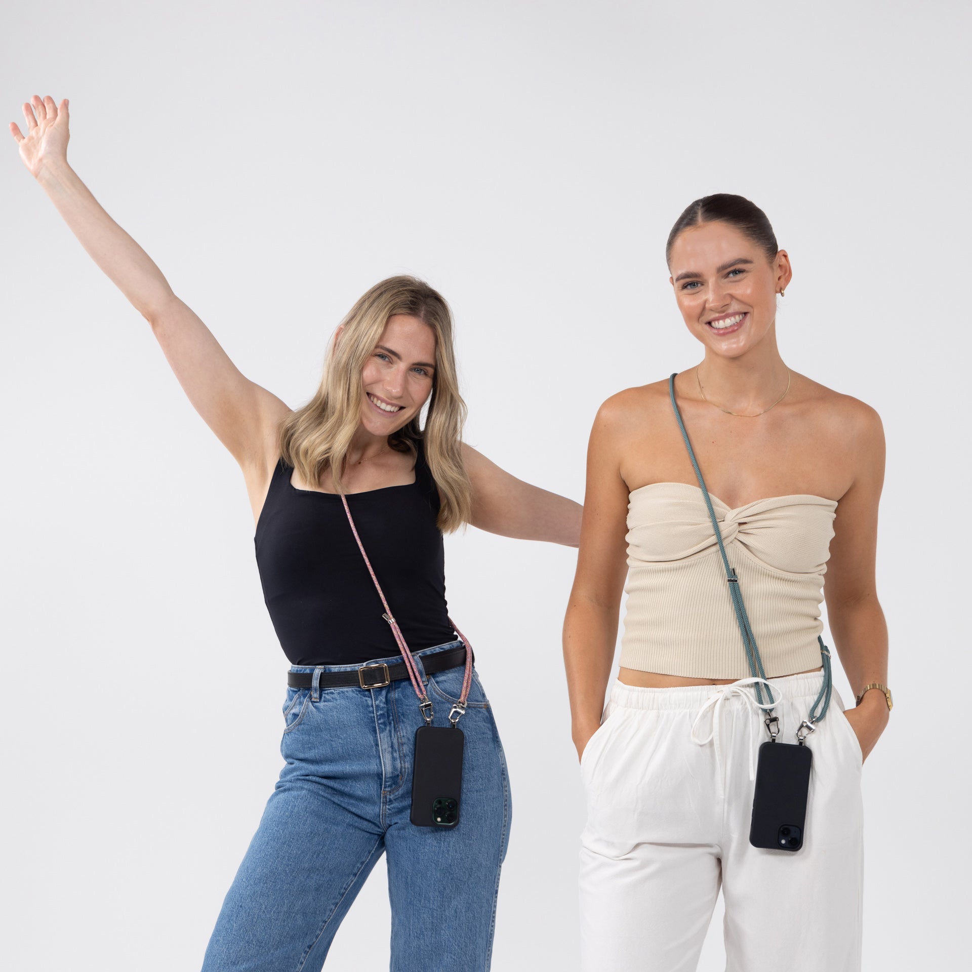 Loop crossbody cords sangria and seafoam with black crossbody phone case being worn by two models