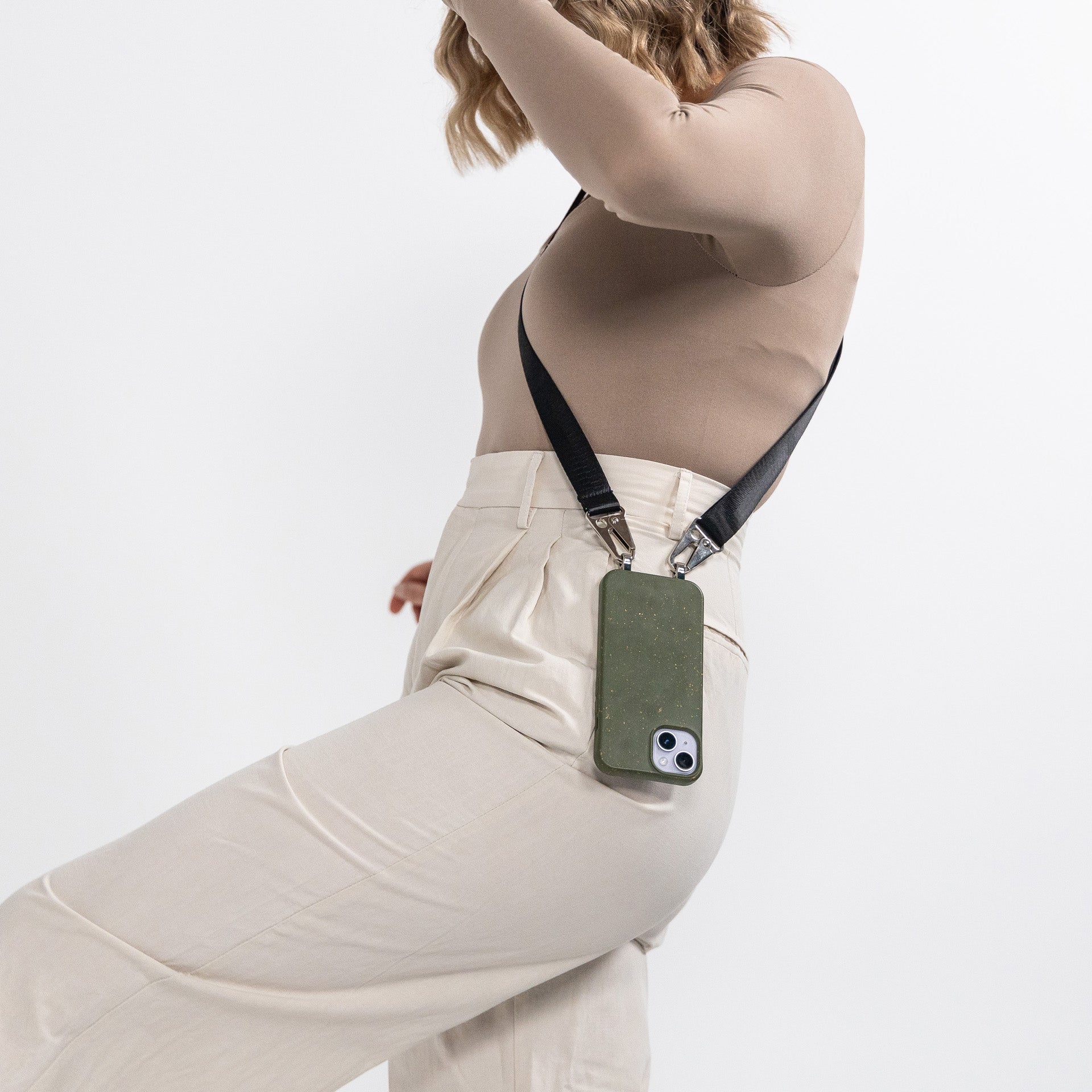 Pesto crossbody phone case with black strap attached hanging over should side profile