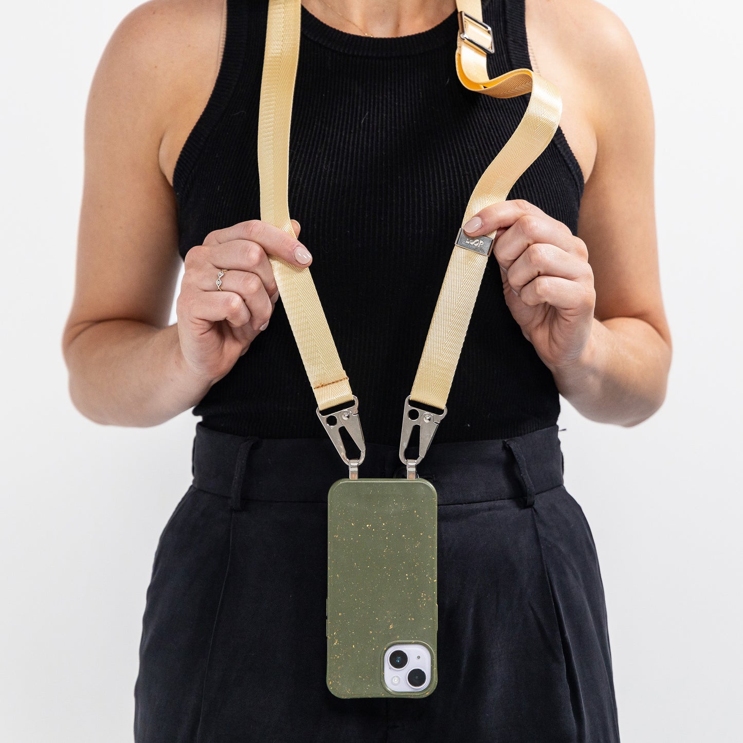 Loop Pesto crossbody phone case with butter phone strap hanging around neck