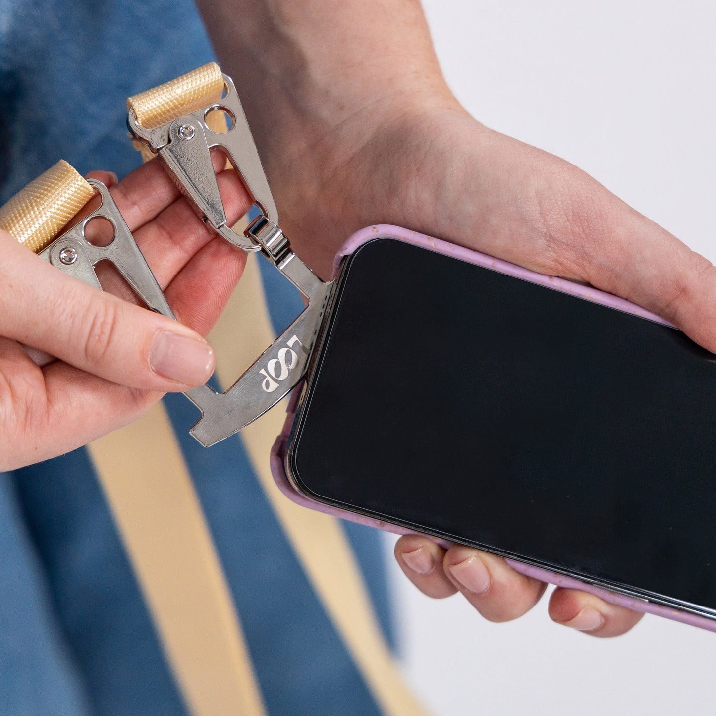 Lavender crossbody phone case with butter strap being inserted into phone case