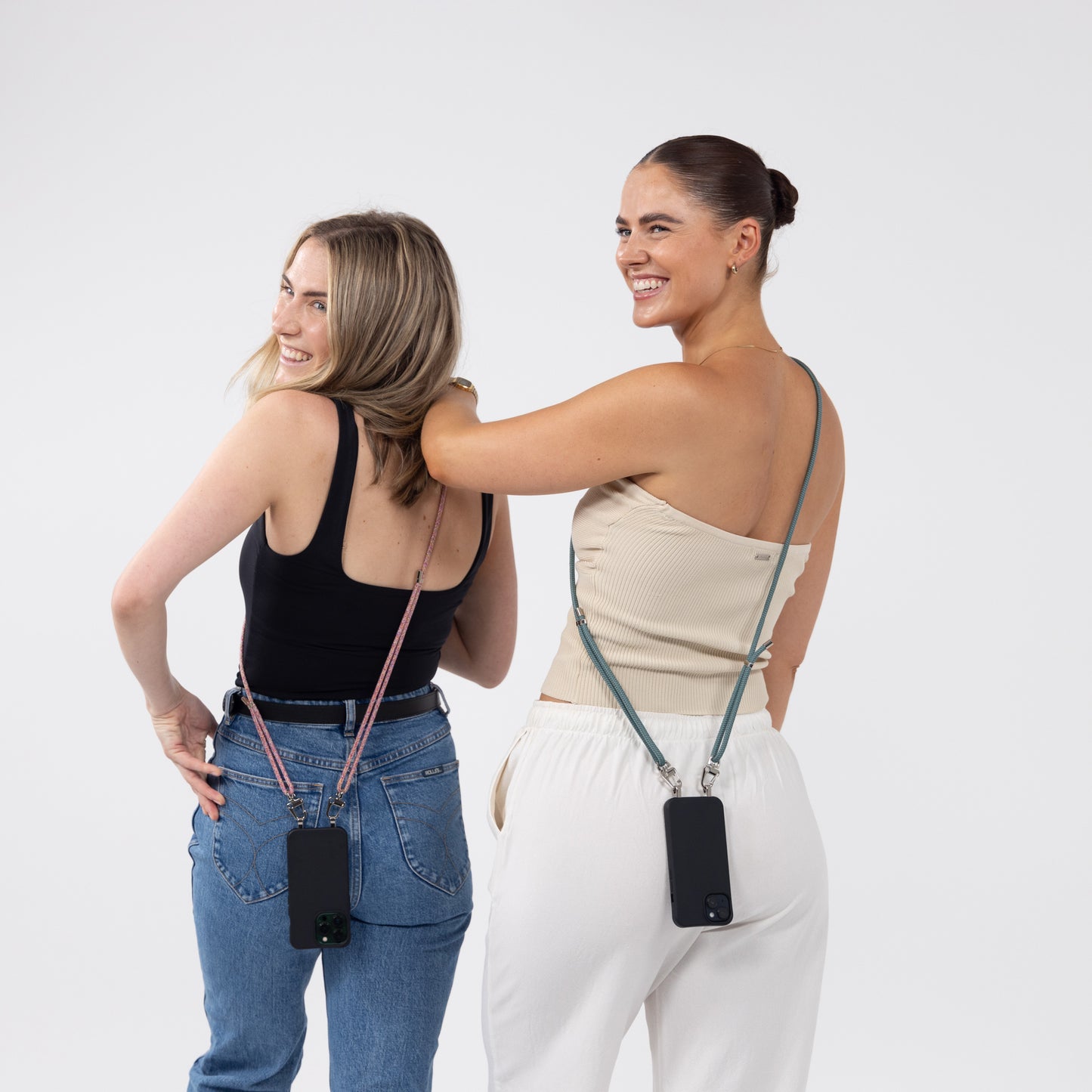 Ink Loop crossbody phone case with seafoam and sangria crossbody strap worn over shoulder from behind