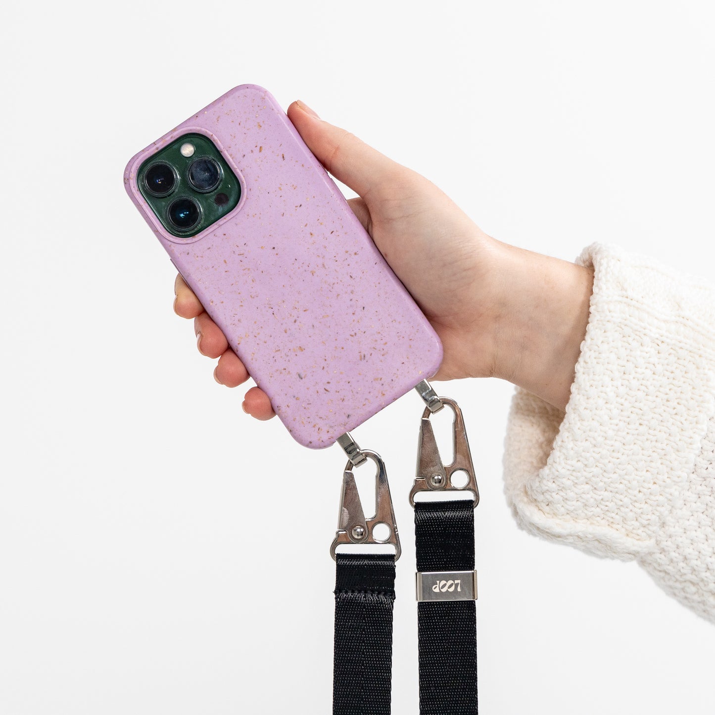 Crossbody phone case lavender with black strap being held in hand rear view