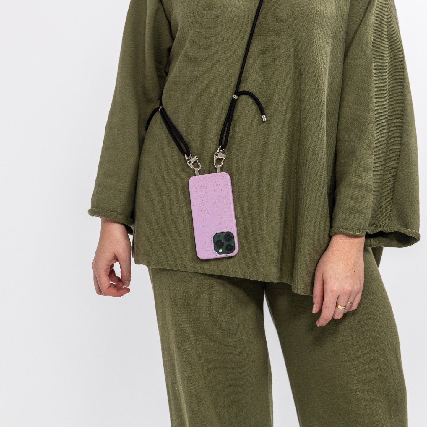 Lavender crossbody phone case with black crossbody cord being worn over shoulder rear view