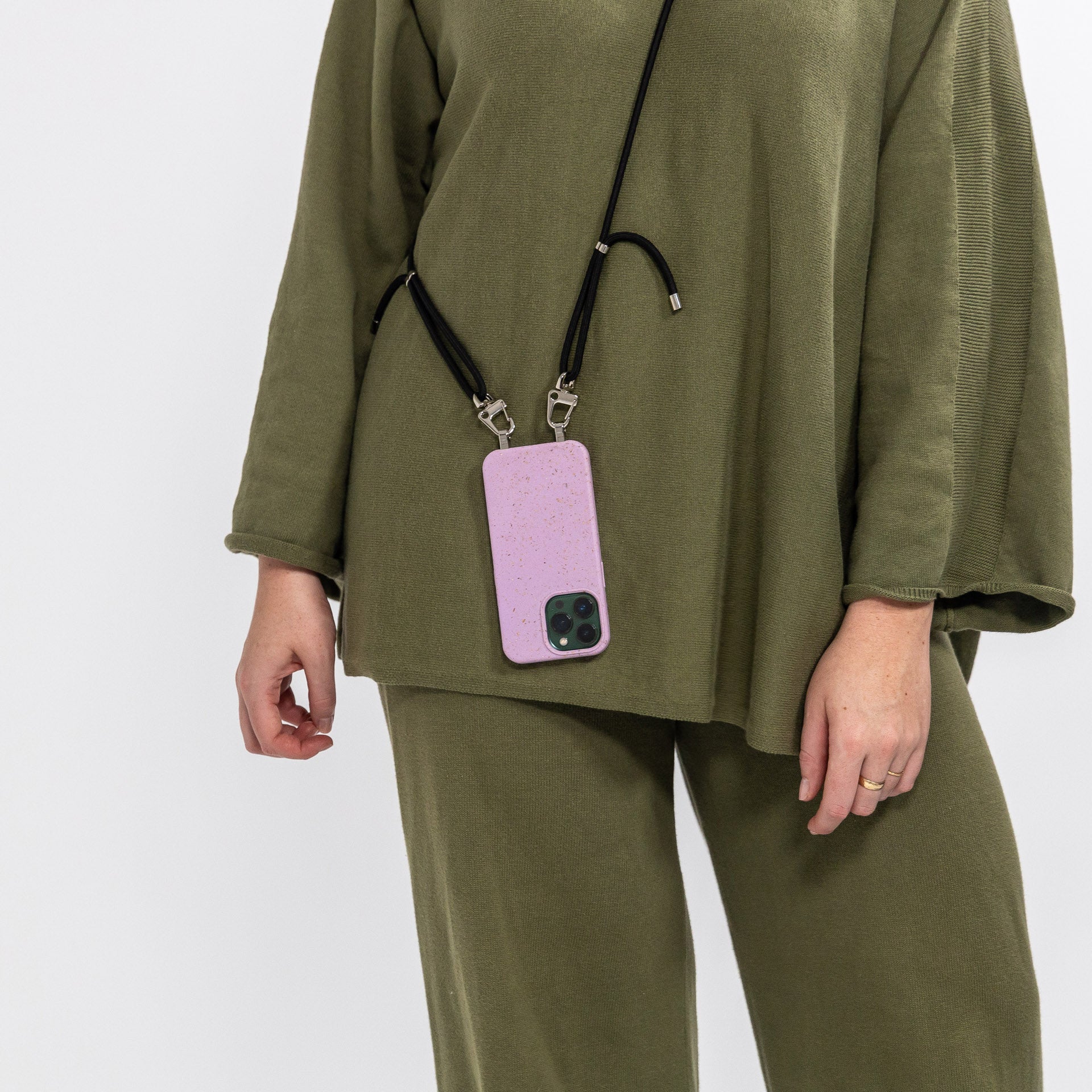 Lavender crossbody phone case with black crossbody cord being worn over shoulder rear view