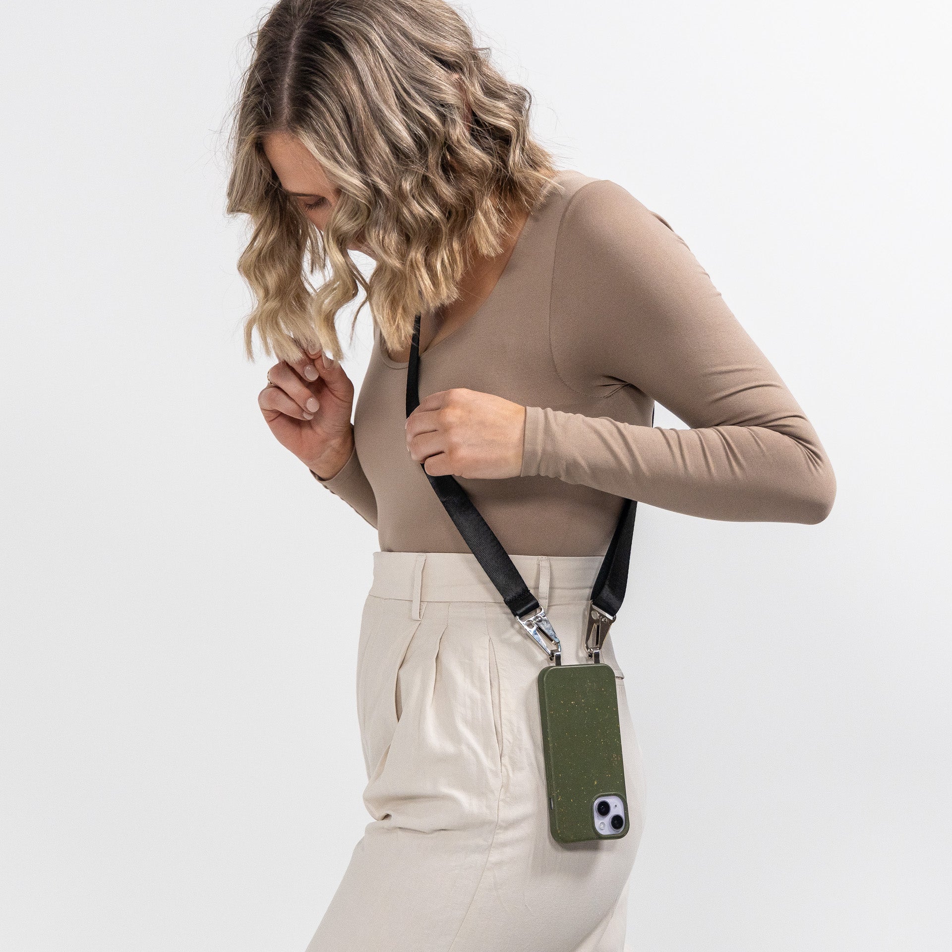 Pesto Loop crossbody phone case with black strap hanging over should side view